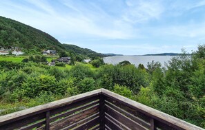 A wooden deck overlooking a lake with houses in the background. - 3 bedroom lovely home in Fister (Fister)