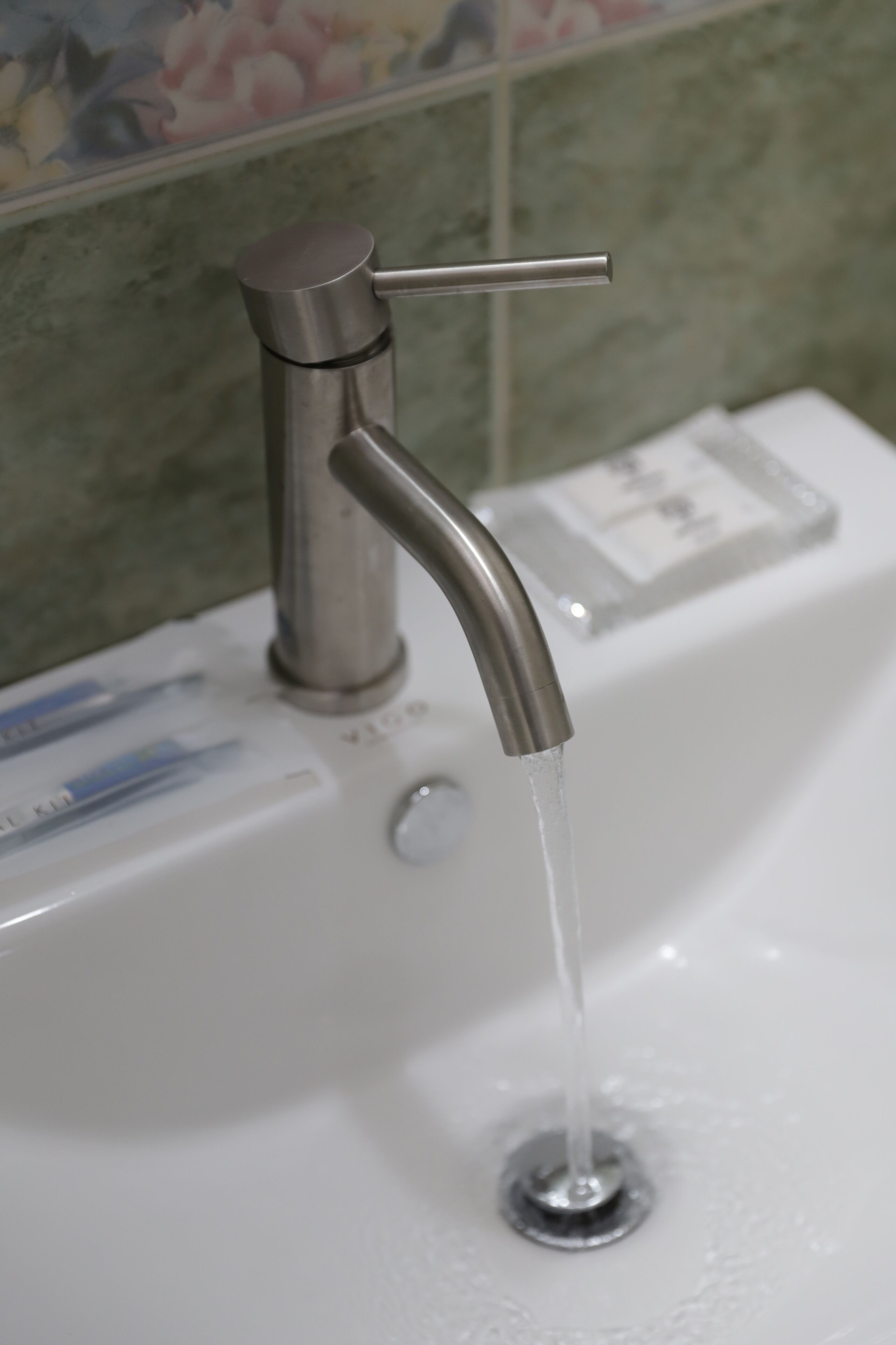 A bathroom sink with a faucet and running water.