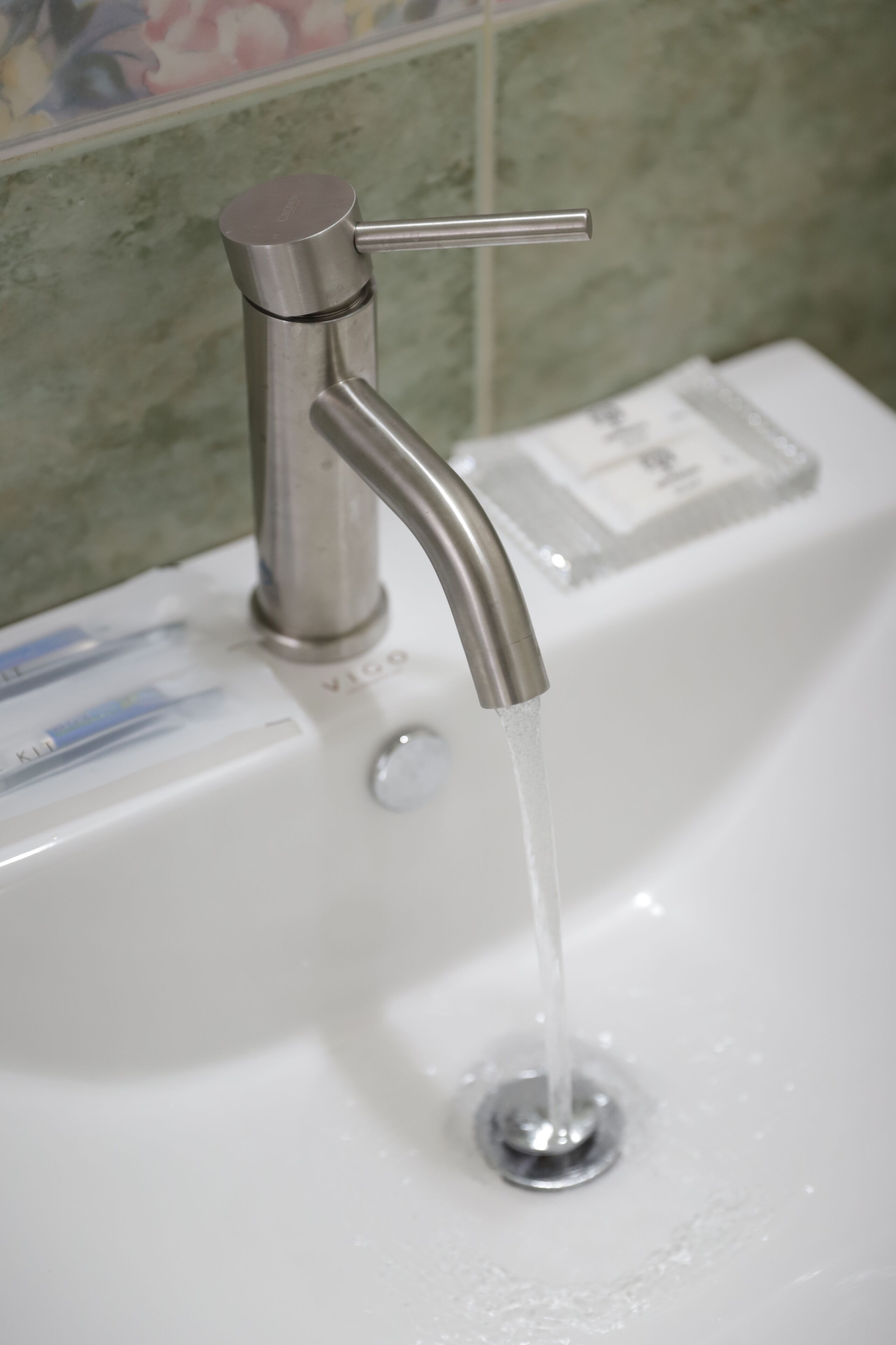 Ein Waschbecken mit einem modernen Wasserhahn und fließendem Wasser.