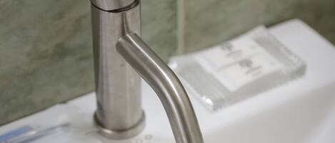 Ein Waschbecken mit einem modernen Wasserhahn und fließendem Wasser.