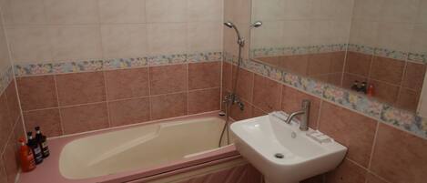 Un bany amb banyera, un lavabo i plat de dutxa.