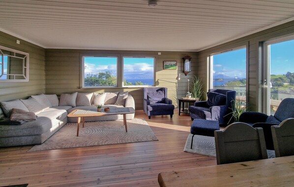 Un salón amplio con piso de madera, un ventanal y vistas al exterior.