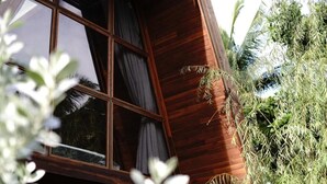 Pared exterior de madera con una ventana y una planta.