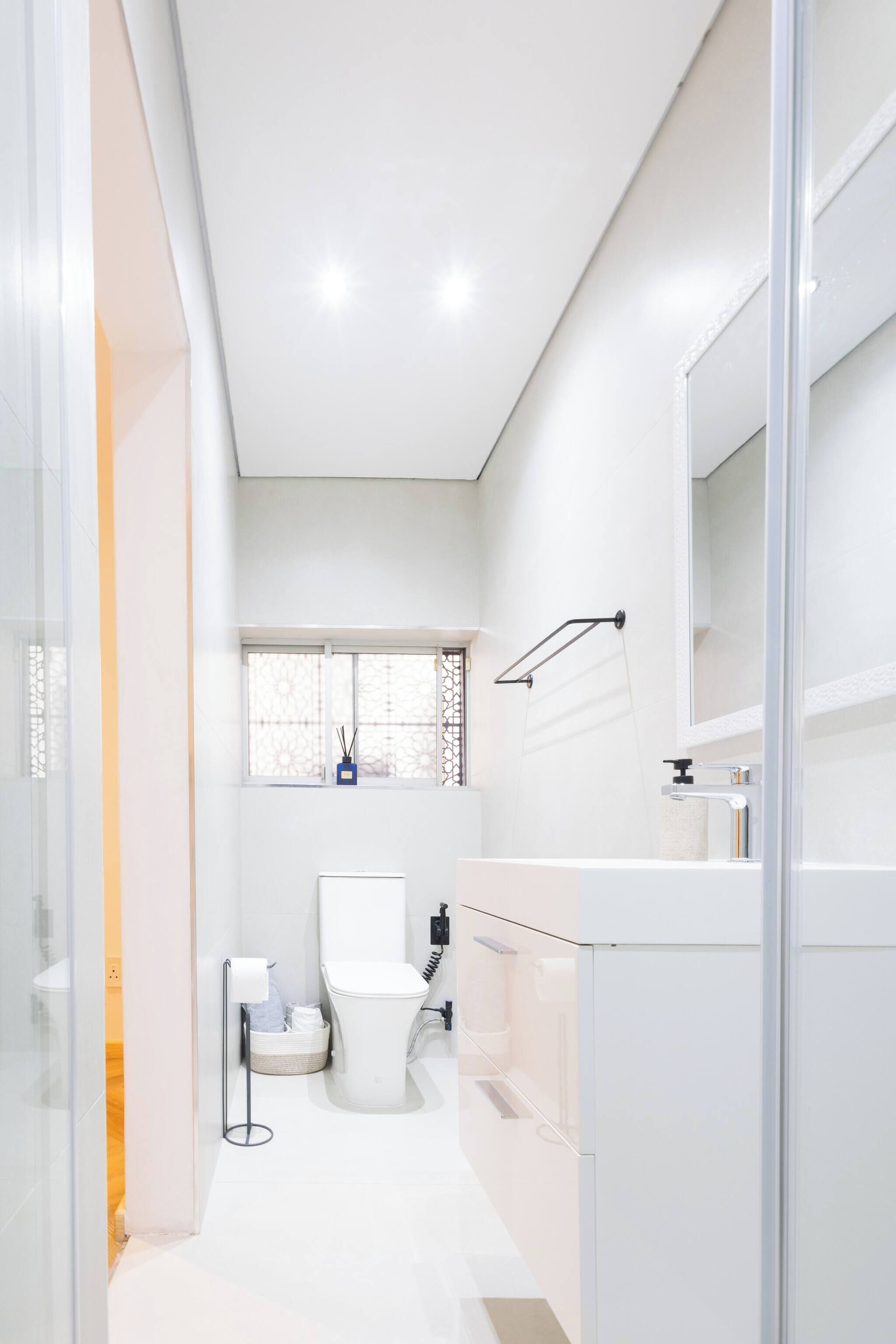 A modern bathroom with a toilet, sink, and mirror.
