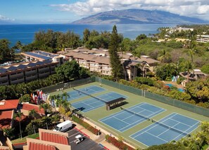 Un complex de pistes de tennis amb diverses pistes, envoltat d'edificis residencials i zones verdes.