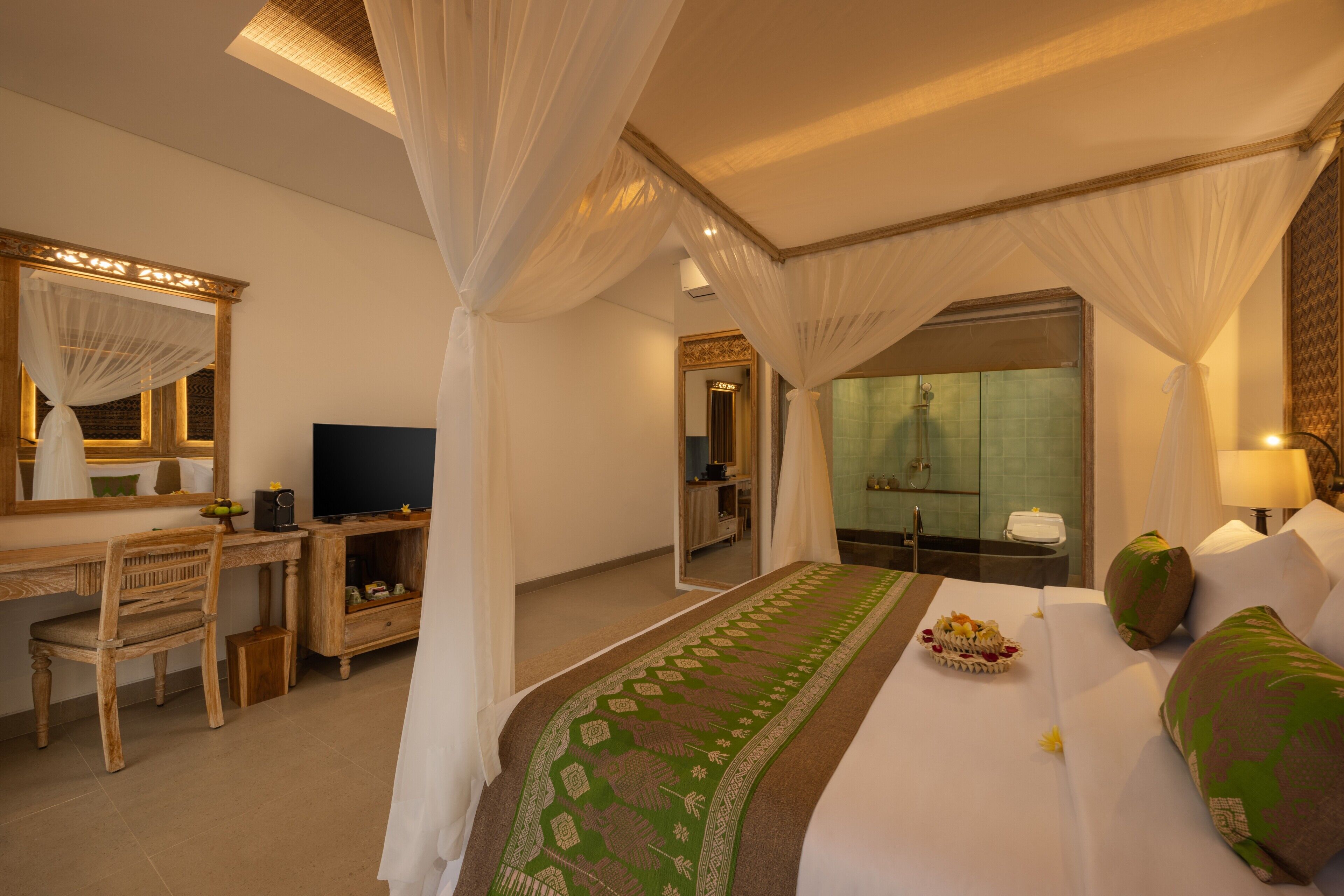 A hotel room with a bed, a desk, a television, a bathroom, and a mirror.