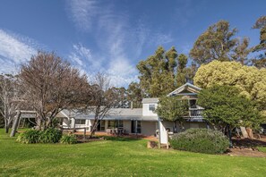 A two-story house with a covered patio and a lawn in front. - Fermoy Lodge—Wine Country Haven & Vineyard Views (Wilyabrup)