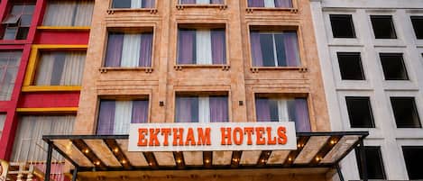 Un edificio de hotel con un letrero que dice 'EKTHAM HOTELS' en la entrada.