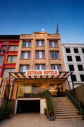 Un edificio de hotel con un letrero que dice 'EKTHAM HOTELS' en la entrada.