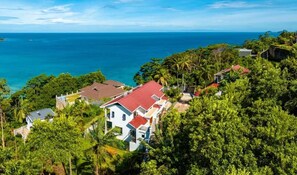 A coastal residential area with houses surrounded by lush greenery and a view of the ocean. - CASA GEM Seychelles (Victoria)