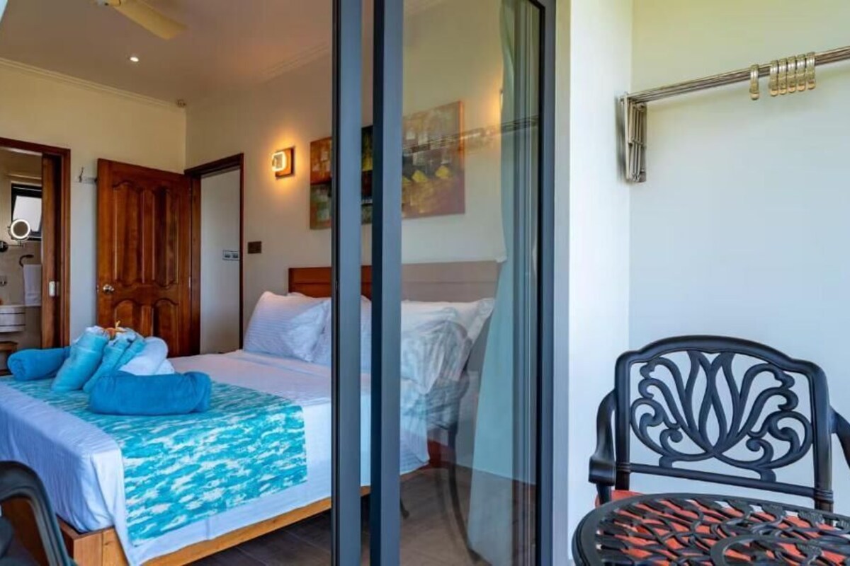 A bedroom with a bed, a chair, and a window.