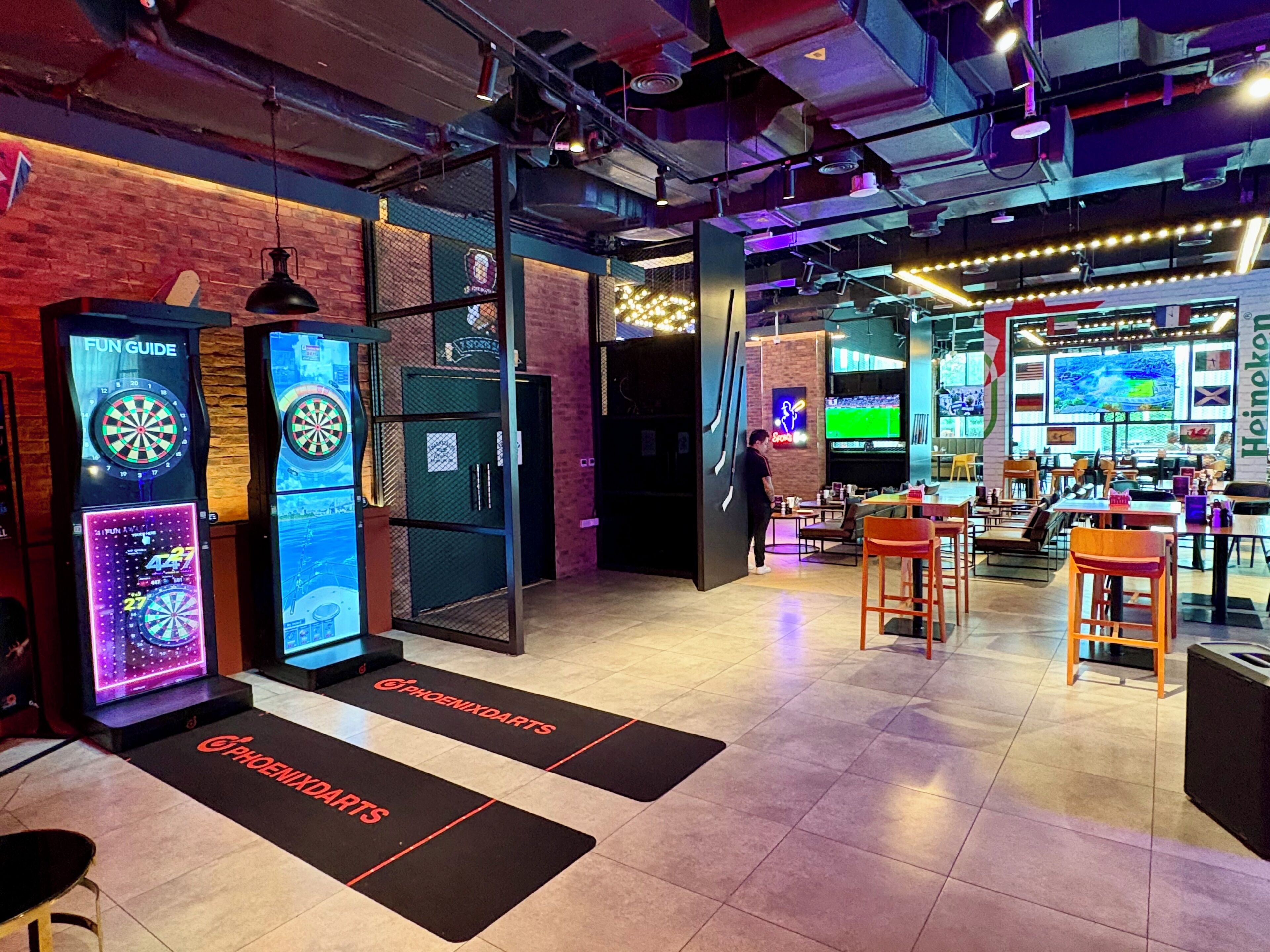 A darts game area with multiple dartboards and a digital scoreboard.