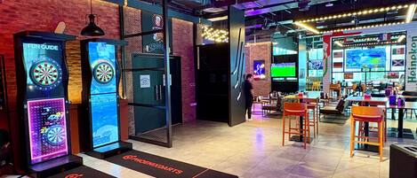 A darts game area with multiple dartboards and a digital scoreboard.