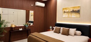 Habitación de hotel con cama, mesitas de noche, un espejo, aire acondicionado de pared y un cuadro.