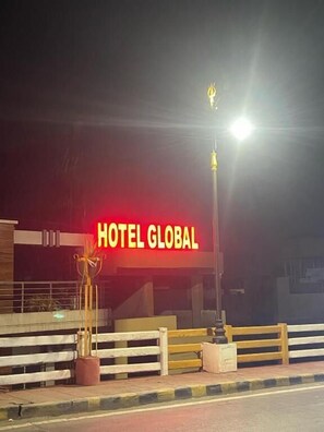 Un letrero de hotel con el nombre 'HOTEL GLOBAL' iluminado durante la noche.