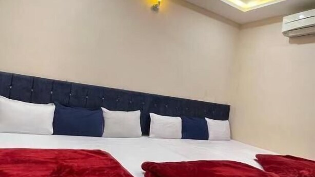 Habitación de hotel con cama, ventilador de techo e iluminación empotrada.