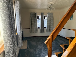 A room with a carpeted floor, a wooden staircase, and a window with curtains. - Fully Furnished Double Bedroom – Excellent Location to city centre. (Coventry)