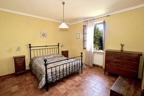 A bedroom with a bed, dresser, nightstands, and a window with curtains. - Apartment in Piazza del Campo area 3 bedrooms 2 bathrooms (Asciano)