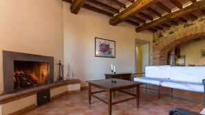 A room with a fireplace, a table, and a sofa.