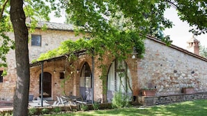 A stone building with a covered patio and outdoor seating.