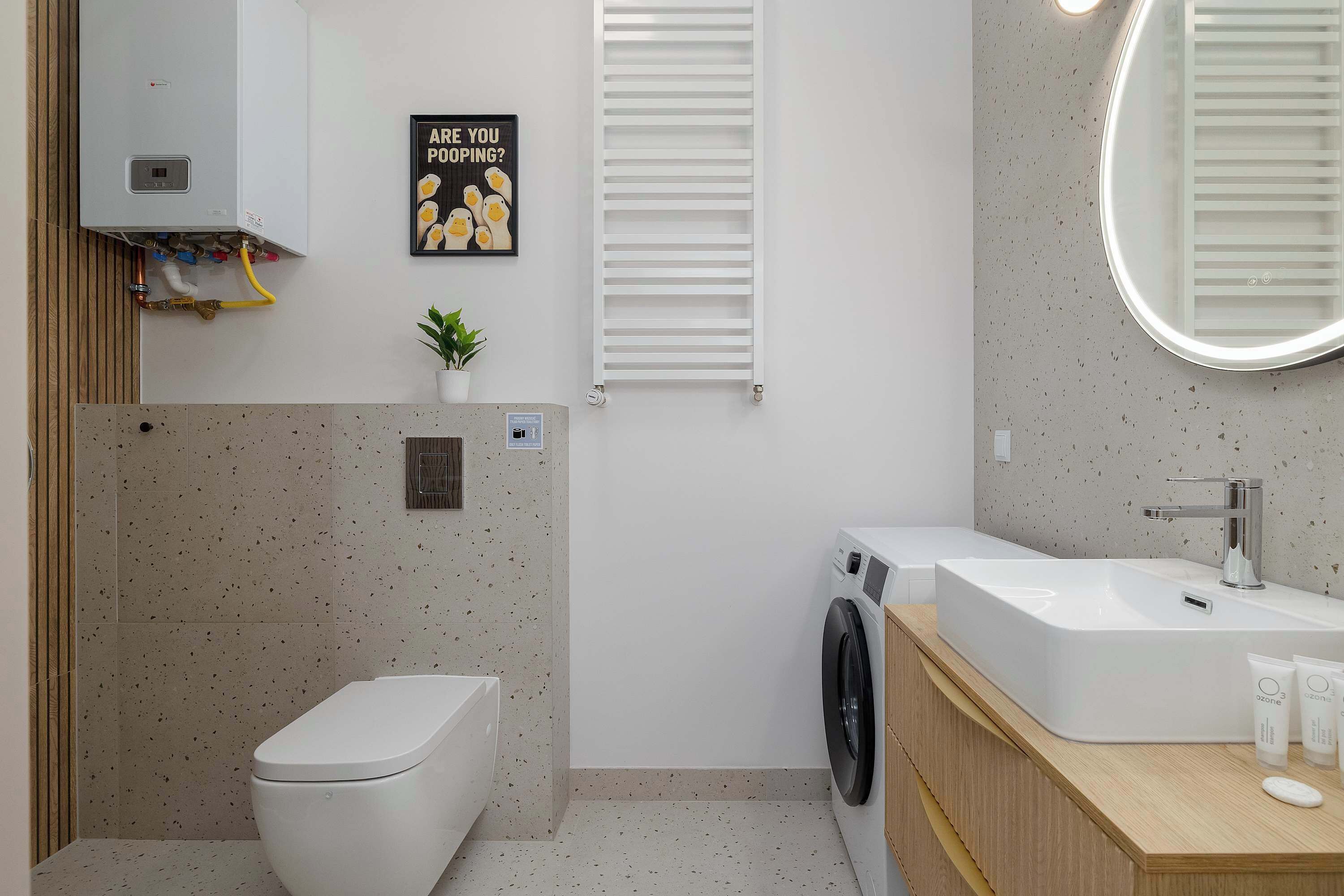 A modern bathroom with a toilet, washing machine, and sink.