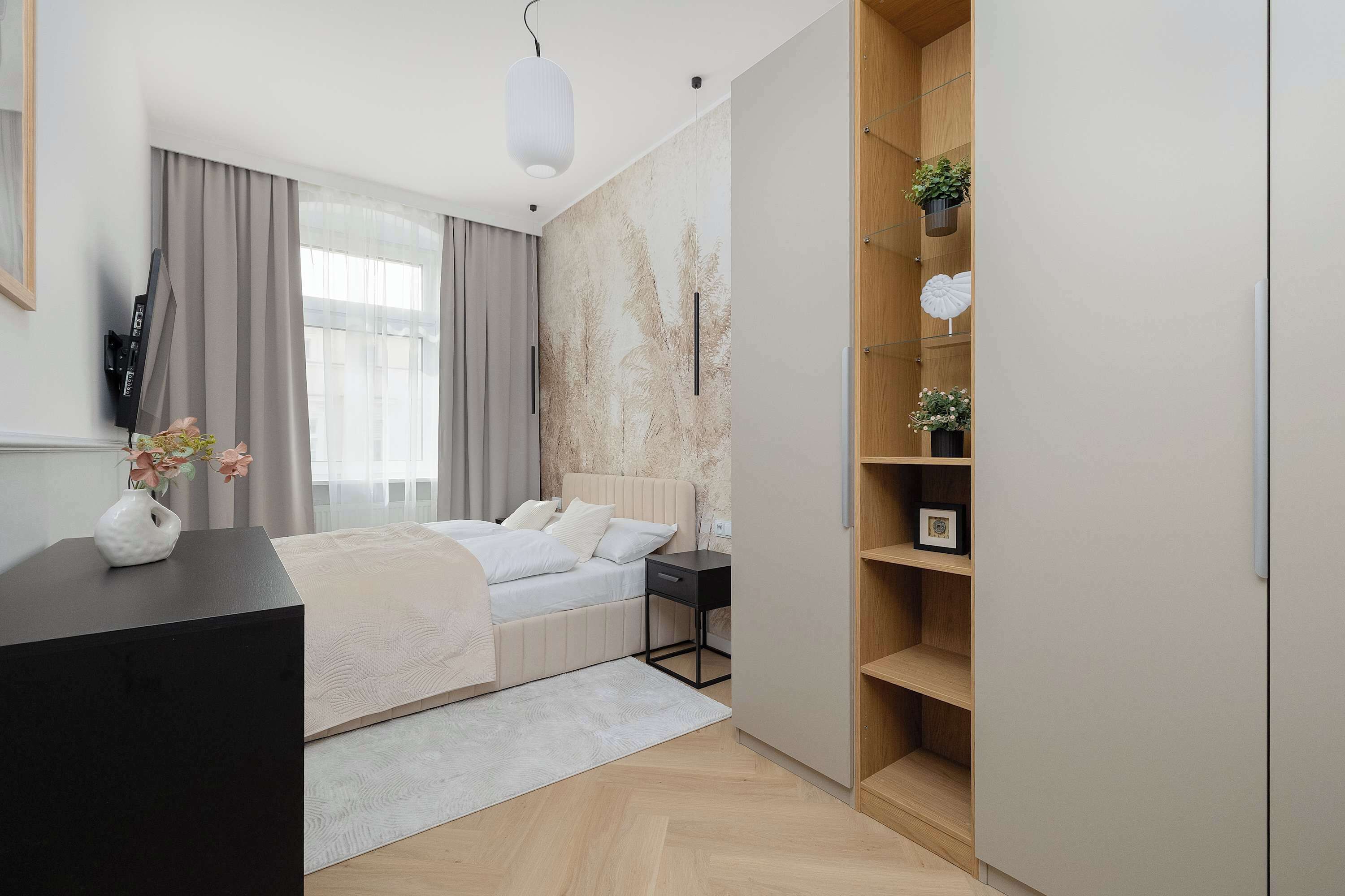 Quarto moderno com cama, mesa de cabeceira e guarda-roupa.