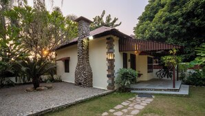 Una casa con fachada de piedra, techo de tejas y porche cubierto.
