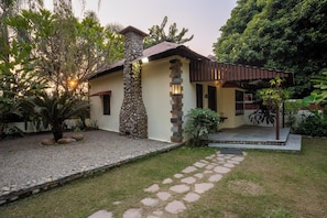 Una casa con fachada de piedra, techo de tejas y porche cubierto.