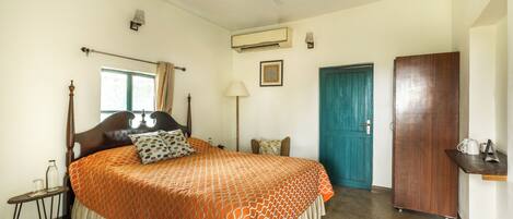 Un dormitorio con cama, ventana, puerta, ventilador de techo y aire acondicionado de pared.