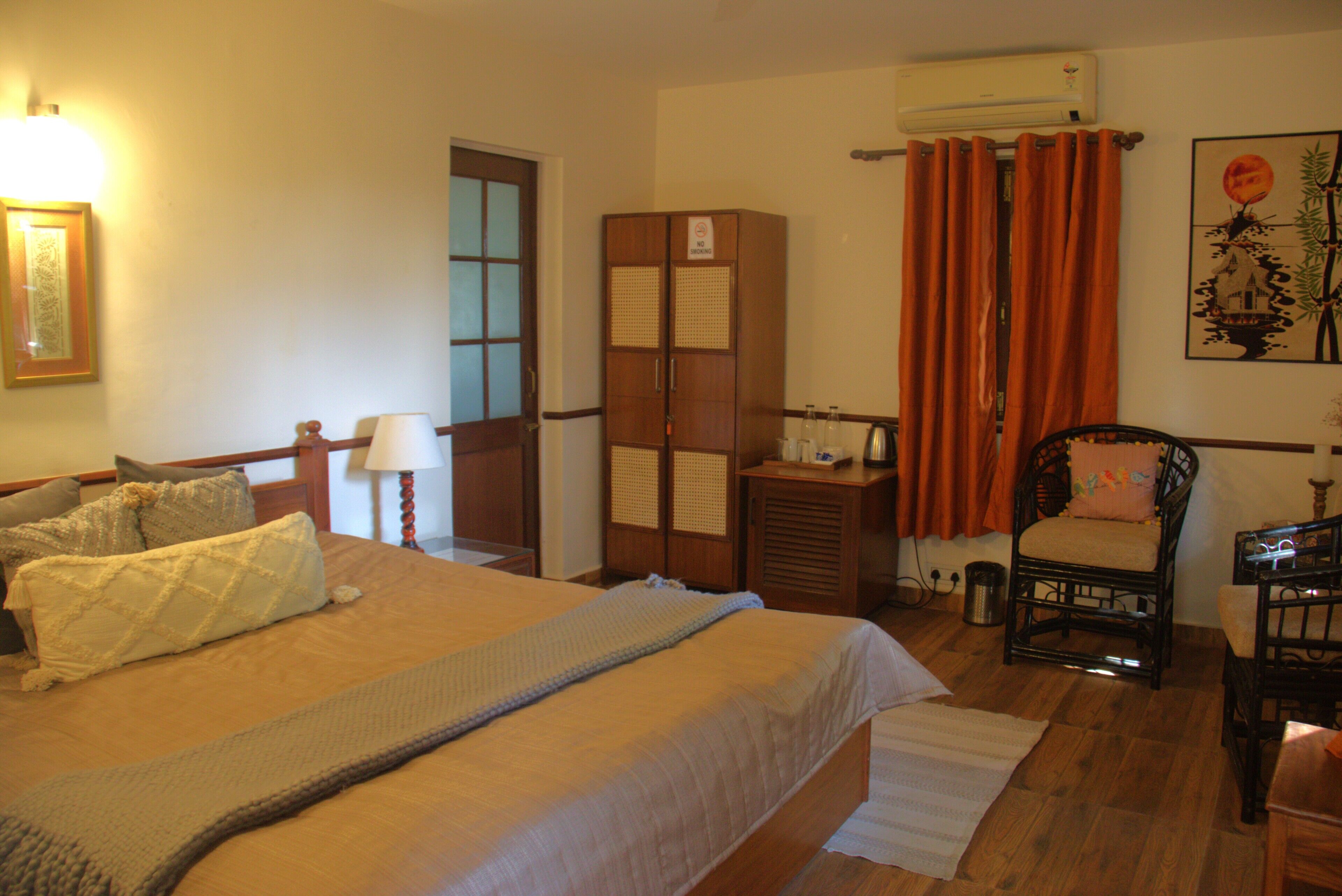 A room with a bed, a chair, a desk, and a wardrobe.