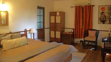 A room with a bed, a chair, a desk, and a wardrobe.