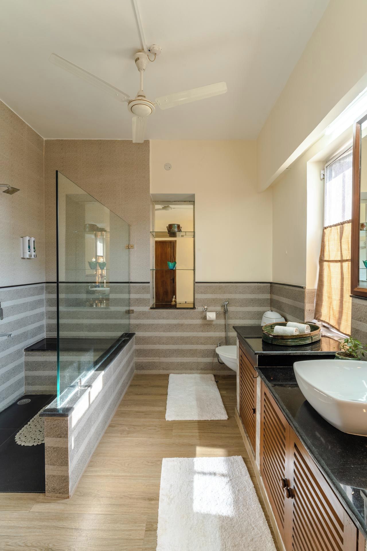 A modern bathroom with a glass shower enclosure, a freestanding bathtub, and a vanity with a sink.
