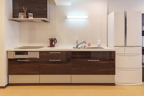 A modern kitchen with a built-in dishwasher, a coffee maker, a sink with a faucet, and a white refrigerator. - SERENE | Kuromon ・ 202 | 3BR ・ 2 Shower Rooms | Private Home for Families and Groups (Osaka)