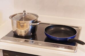 A kitchen with a stove, a pot, and a pan. - SERENE | Kuromon ・ 202 | 3BR ・ 2 Shower Rooms | Private Home for Families and Groups (Osaka)