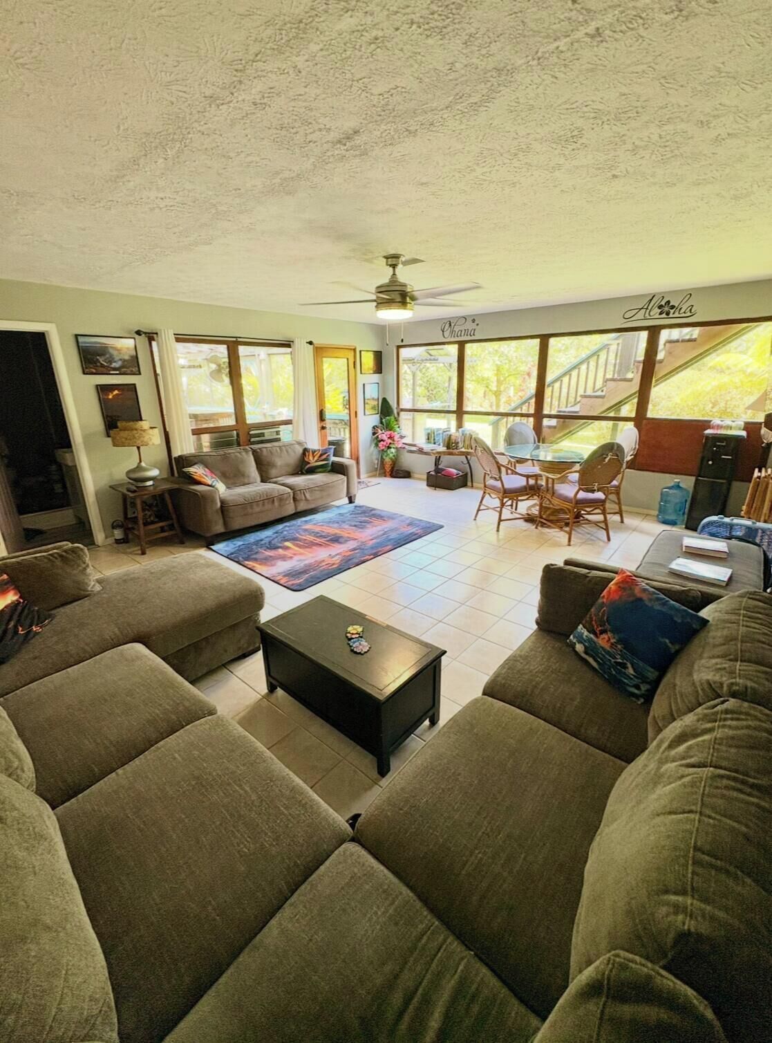 A spacious living room with a sofa set, a coffee table, and a dining area with chairs.