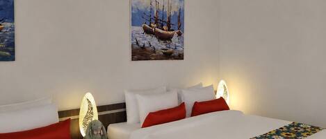 A hotel room with two beds, white bedding, red pillows, a floral bedspread, a painting of boats on the wall, and a nightstand with a lamp.