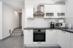 A modern kitchen with white cabinetry, a built-in oven, a coffee maker, and a microwave. - Villa Fontane (100521-K1) - Funtana (Porec) (Funtana (Porec))