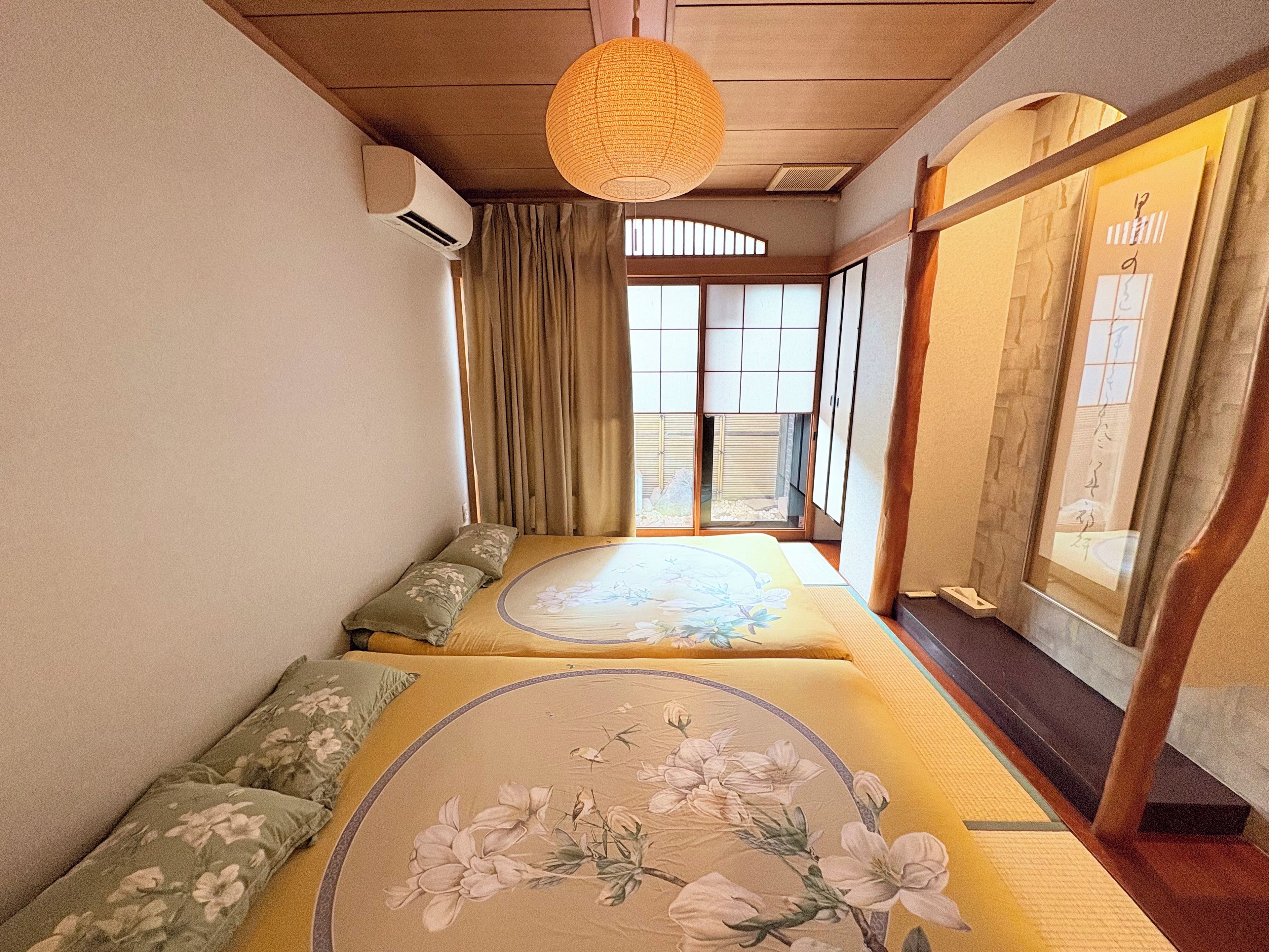 Une pièce de style japonais traditionnel, avec un sol recouvert de tatamis, une table basse et des portes coulissantes.