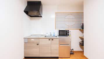 A compact kitchen with a microwave, refrigerator, and a sink.
