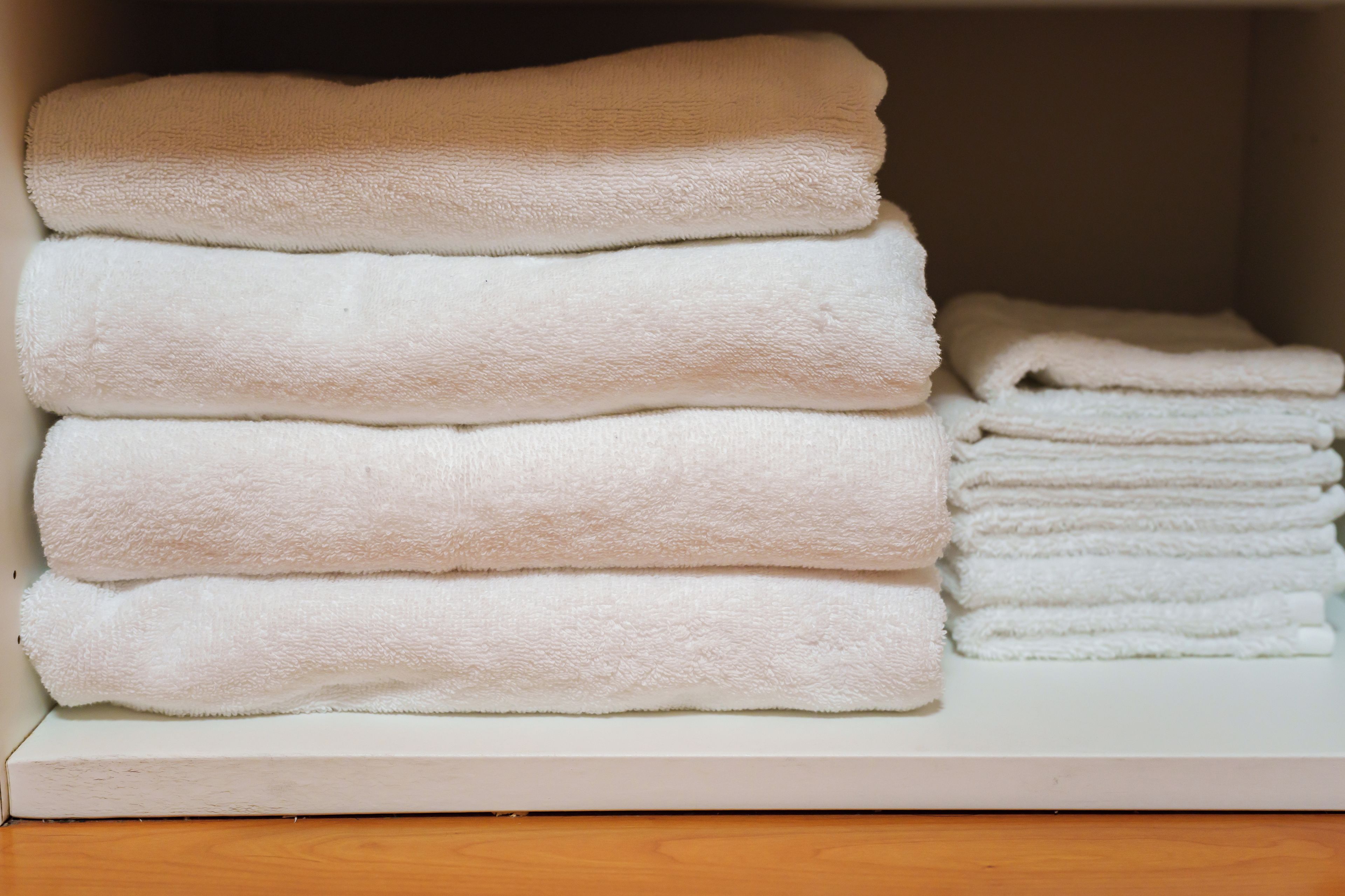 Une pile de serviettes blanches dans un espace de rangement.