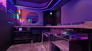 Uma cozinha moderna com bancada de mármore, eletrodomésticos embutidos e um letreiro de neon.