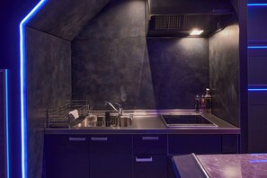 Eine moderne Küche mit einer Edelstahl-Arbeitsplatte, einem eingebauten Backofen und einer Dunstabzugshaube.