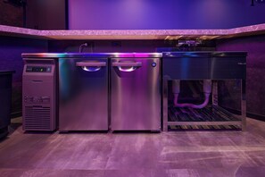 A commercial kitchen with stainless steel appliances, including a refrigerator, freezer, and ice maker. - Tsukian (Osaka)