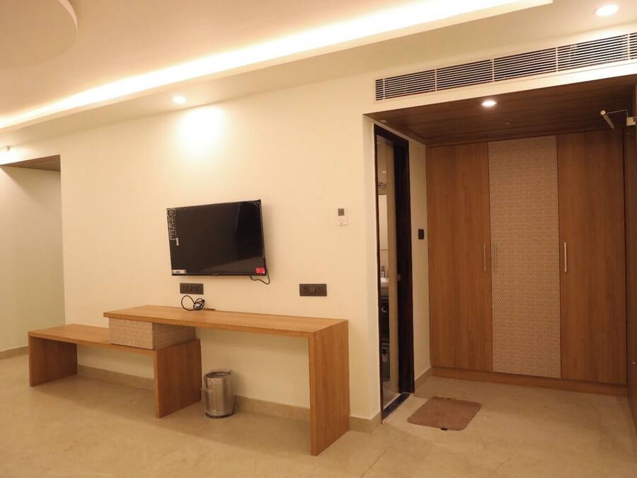 A modern room with a wooden desk, a television, and a wardrobe.