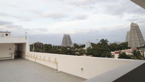 A rooftop terrace with a view of temple structures.
