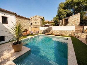 A swimming pool with stone walls and a potted plant. - Stone house with a pool just outside Uzès (Garrigues-Sainte-Eulalie)