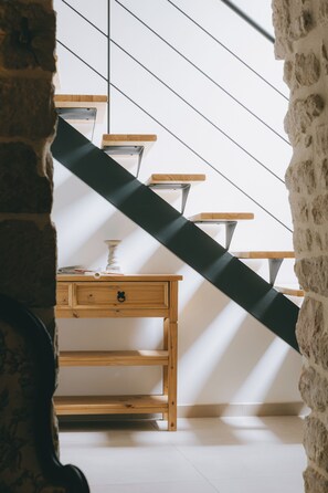 A staircase with wooden steps and a black handrail, leading to a room with a wooden desk and a white wall. - Stone house with a pool just outside Uzès (Garrigues-Sainte-Eulalie)