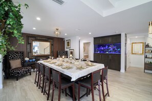 A dining area with a long table set for six, surrounded by dark wooden chairs. - Boater’s Paradise – 60’ Slip & No Fixed Bridges (Boca Raton)