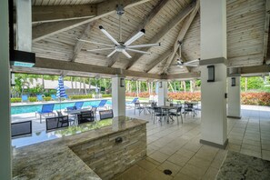 A covered outdoor area with a pool, lounge chairs, and tables. - Boater’s Paradise – 60’ Slip & No Fixed Bridges (Boca Raton)