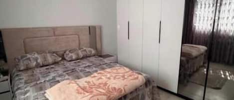 Une chambre à coucher avec un lit, une armoire et un miroir.